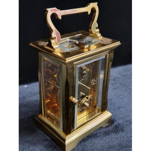 241 - A heavy brass antique carriage clock by David Peterson with bevelled glass. With  exposed fly wheel ... 