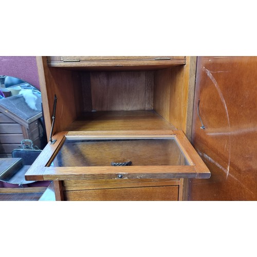 748 - A very tall early 1900s walnut cupboard with 7 interior drawers the top two having glass fronts.  Al... 