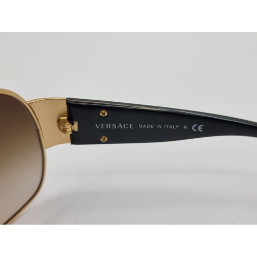 421 - A good pair of original  Versace, made in Italy, wraparound style sunglasses. Lenses in good order. ... 