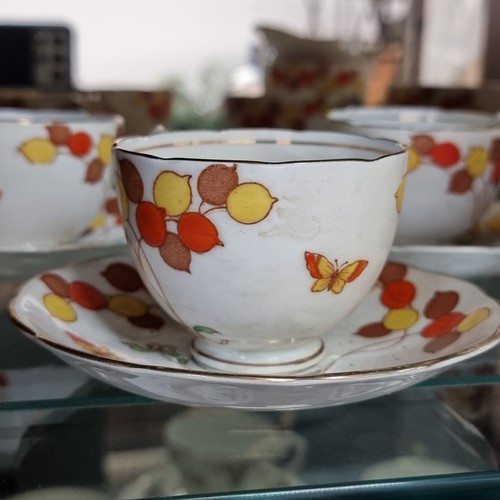 595 - Eight pieces of Diamond china with a charming orange and yellow berry and butterfly motif.