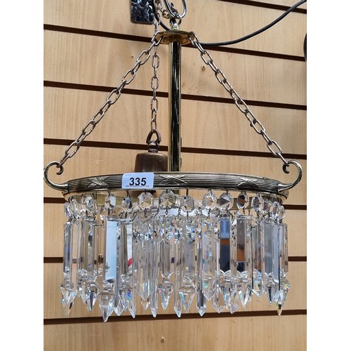 335 - A vintage Art Deco style chandelier with a brass frame, cut glass drop prism and tear drop pendants.... 