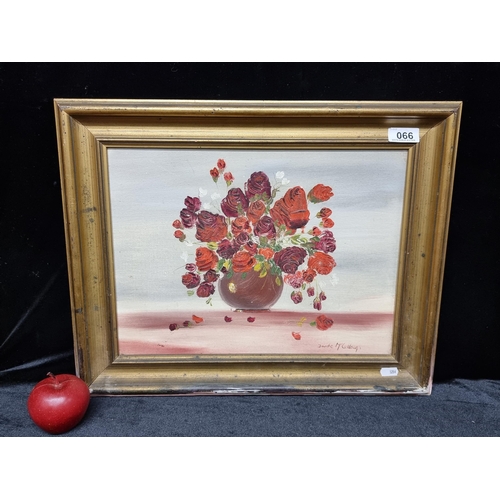 66 - An original oil on board still life of roses in a vase signed by artist Deirdre McCullough.