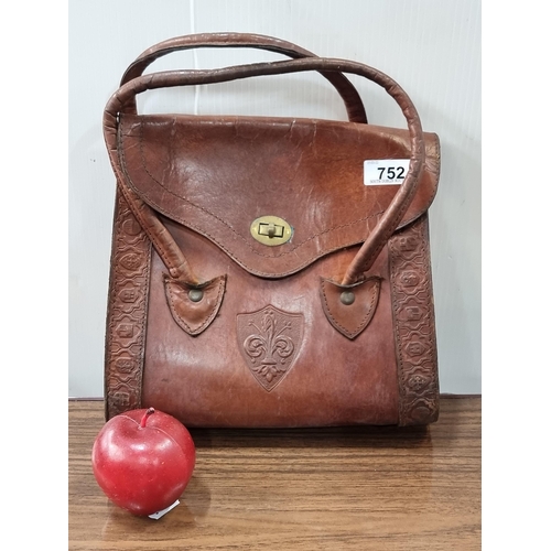 752 - A beautiful vintage ladies tan leather handbag with embossed fleur-de-lis to centre and a boarder of... 