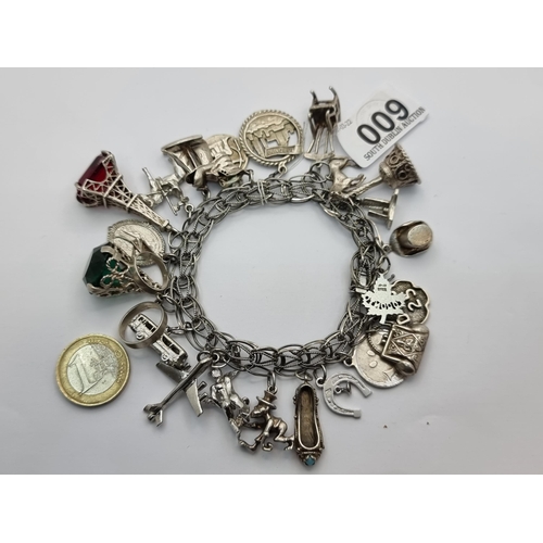 9 - A very attractive sterling silver charm bracelet, containing in excess of 25 charms. Two of which co... 