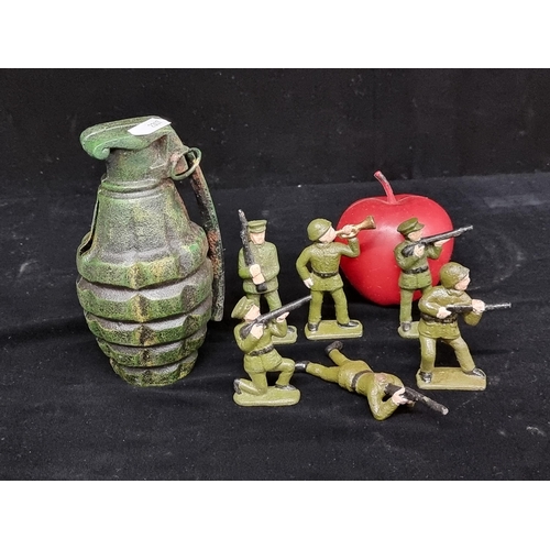 152 - A collection of seven vintage cast metal military models, including six hand painted soldiers engage... 