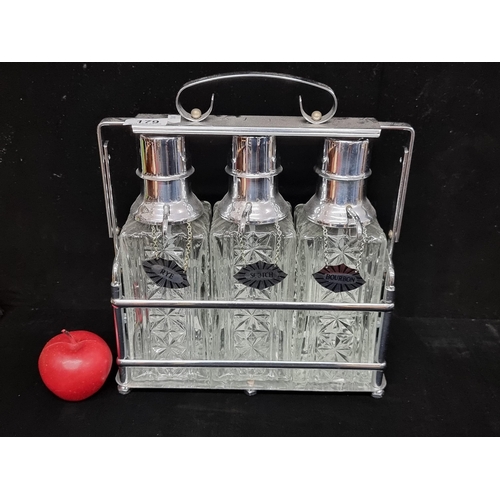 179 - A super tantalus with three decanters in an antique style. Each bottle is equipped with spouts and b... 