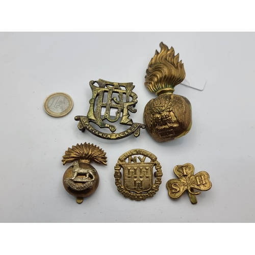 12 - A collection of five British and Irish army badges, including a Thomes E. Norton badge (1876-1918), ... 