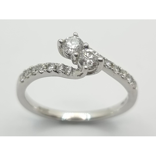23 - Star Lot: An attractive dual stone twist set 9ct gold diamond ring, set with round, brilliantly cut ... 