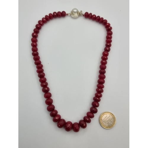 26 - An attractive graduated facet cut natural ruby stone necklace with a pretty sterling set pearl clasp... 