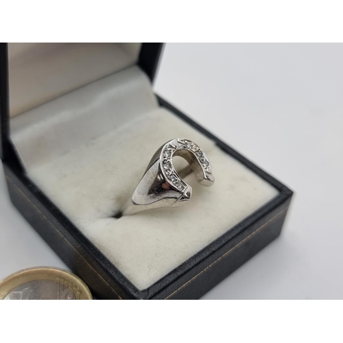 35 - Star Lot : A fantastic 9K white gold Gents diamond set horseshoe ring. Ring size S, weight 7.05g.