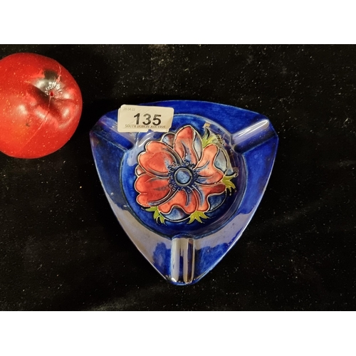 135 - A stunning vintage Moorcroft ceramic ashtray in a deep blue glaze with a red anemone flower to centr... 