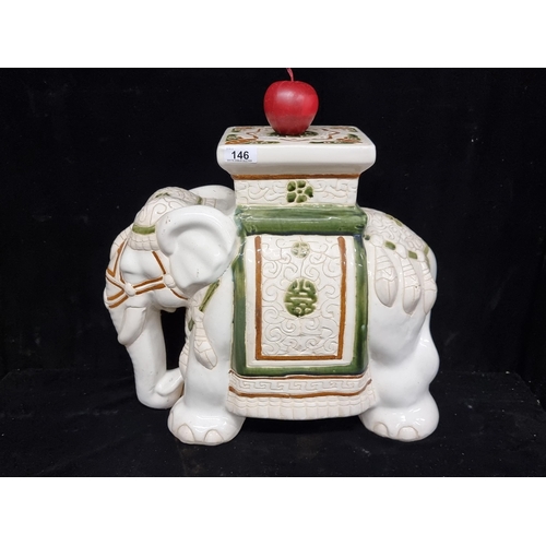 146 - A wonderful ceramic plant stand in the form of an elephant. Glazed in ivory with forest green and um... 