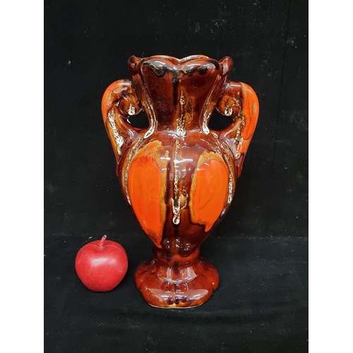 180 - A 1960's Fat Lava ceramic vase. In striking shades of orange, brown and ivory. In a classic amphora ... 