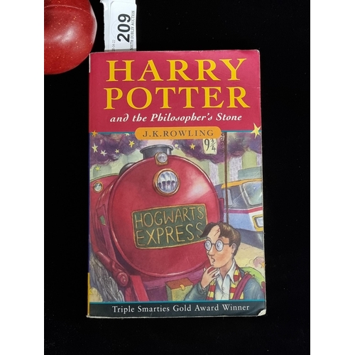 209 - A first edition paperback copy of the book Harry Potter and the Philosopher's Stone by J. K Rowling.... 