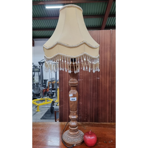 484 - An elegant wooden turned lamp in a classical style, with foliate detailing to base. Finished with a ... 