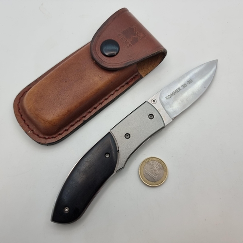 731 - A CRKT brand Kommer 30-30 knife with black handle and branded leather pouch.