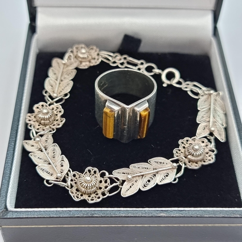 416 - An intricately designed sterling silver bracelet. Length 18cm. Together with a sterling silver desig... 