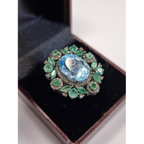 255 - Star Lot : A seriously pretty large Topaz, diamond and Emerald ring. The Huge Central blue topaz is ... 