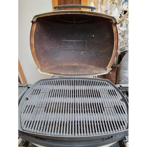 326 - A Weber brand barbecue grill, a 'Q' 300 model. A two burner grill on a folding stand with wheels for... 