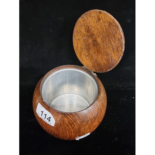 114 - A vintage Art Deco oak spherical tobacco barrel  on feet, with hinged lid and removable stainless st... 