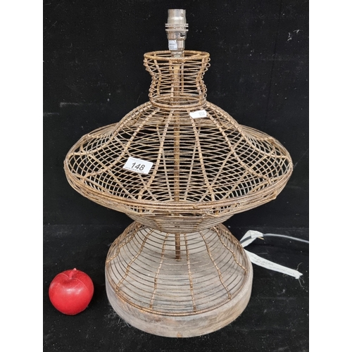 148 - An unusual vintage bent wire table lamp. With a basket-like body on a heavy wooden base. Rewired and... 