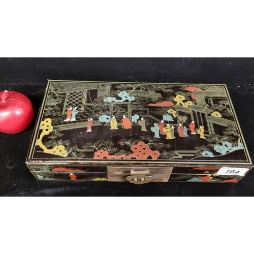 164 - An antique Japanese lacquer box with brass clasp and a hand painted court scene to top.