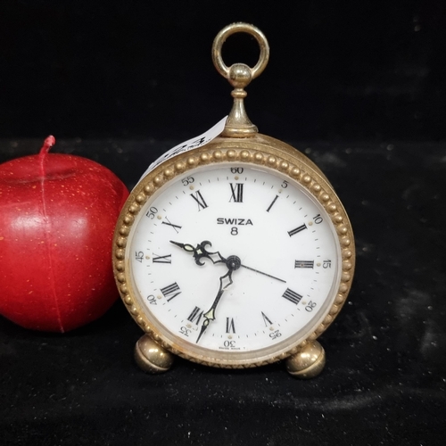 223 - A vintage elegant Swiss, freestanding alarm clock by ''Swiza 8''.  In a brass case with a beaded bor... 