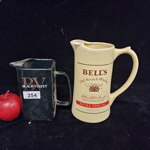 254 - A pair of vintage ceramic advertising pitcher jugs including a Wade example for Bell's Old Scotch Wh... 