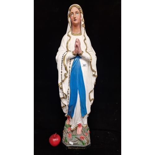 267 - A very large figure of Our Lady of Lourdes, hand painted in vibrant tones, with gilded edging to her... 