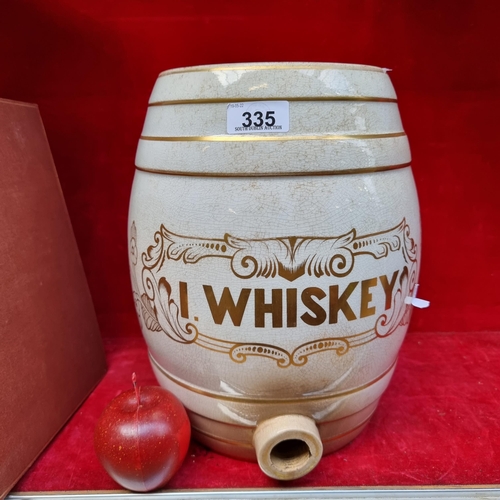 335 - A large porcelain whiskey barrel with space for tap on base reading 