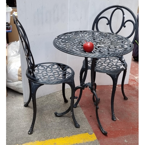 383 - A good cast metal outdoor set including table and two spoon back chairs, all decorated with profuse ... 