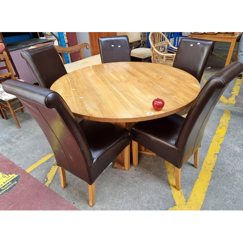 388 - A good sized dining set including a solid oak round dining table and five very comfortable leather u... 