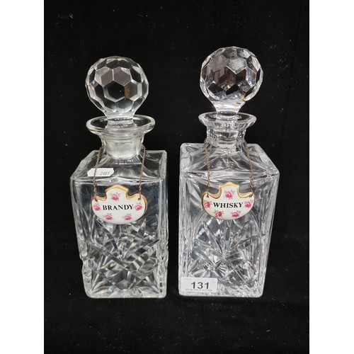 131 - A pair of heavy crystal decanters with deep fan cuts and large faceted stoppers, with fine bone chin... 