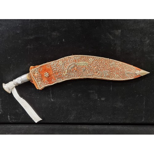 204 - A handsome and very large Kukuri knife. Fitted with a very ornately beaded scabbard and aluminium hi... 