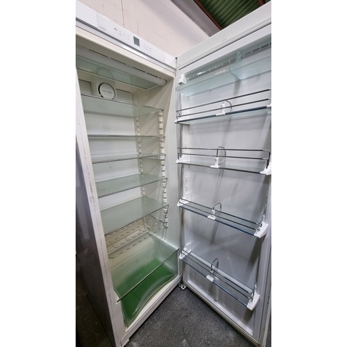 385 - A tall Liebherr refrigerator in white with 7 shelves and storage compartments inside for plenty of s... 