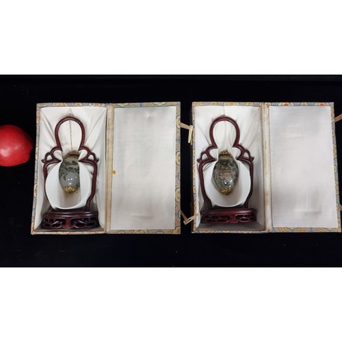 235 - A pair of vintage Chinese interior painted glass egg shaped baubles. Suspended on pierced rosewood f... 