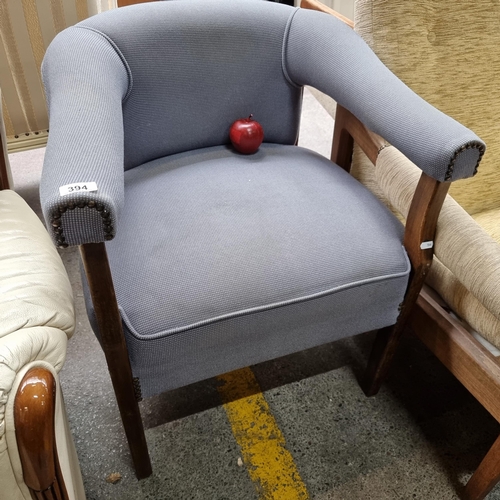 394 - A lovely open arm chair with wooden legs, upholstered in a chic grey fabric with stud detailing.