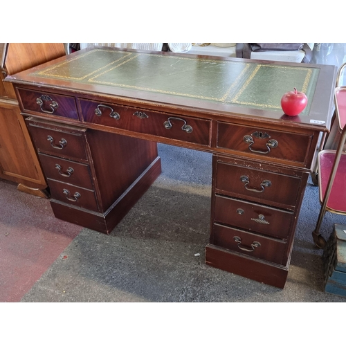 608 - Star lot : A large antique mahogany desk with nine drawers with brass drop pull handles and a green ... 