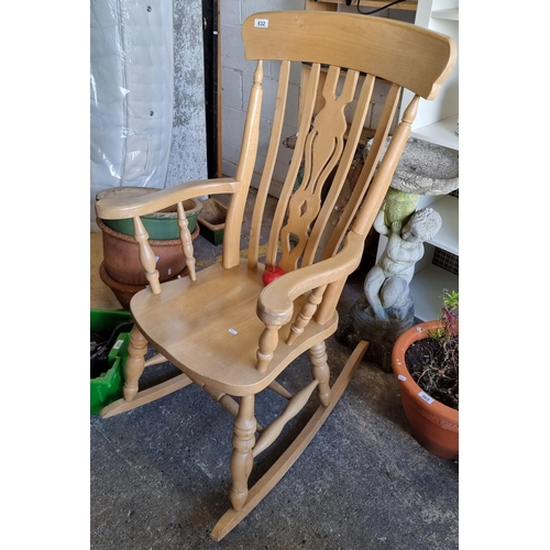 632 - A large contemporary rocking chair in a light wood with railed back. In great condition.