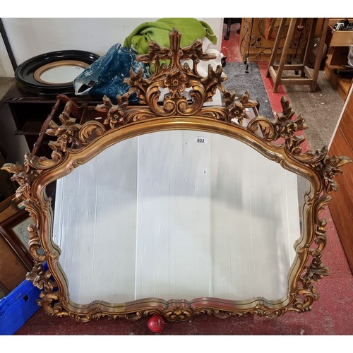 633 - A very large over mantle Louis XV style mirror with highly ornate foliate gilt frame.