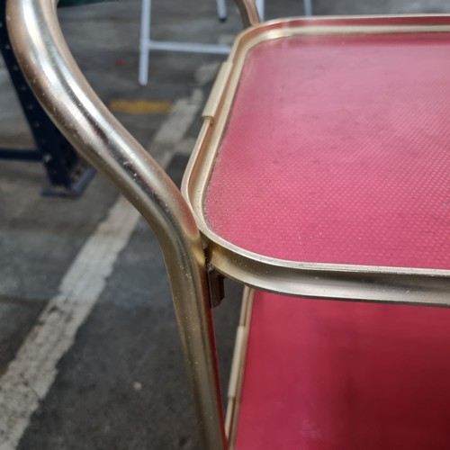 625 - A lovely two tiered chrome vintage drinks trolly with textured red tops, all held on castors.