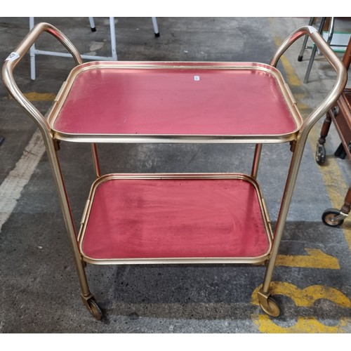 625 - A lovely two tiered chrome vintage drinks trolly with textured red tops, all held on castors.