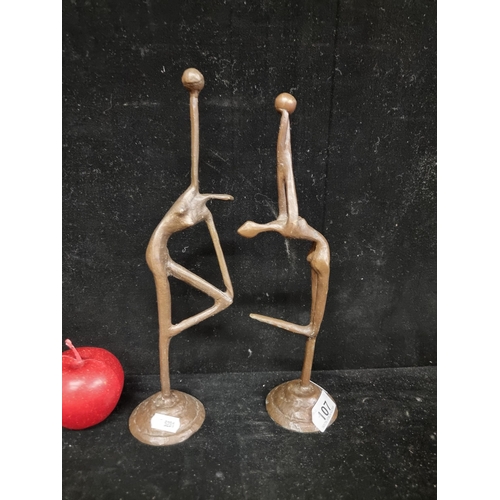 107 - An attractive pair of brass art studies of gymnasts in dynamic poses. H30 cms & 32 cms respectively.