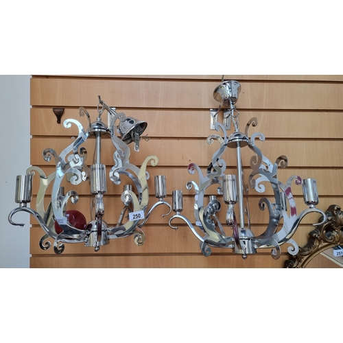 250 - A pair of elaborate five-branch chrome chandeliers. With modern scroll detail and polished finish.