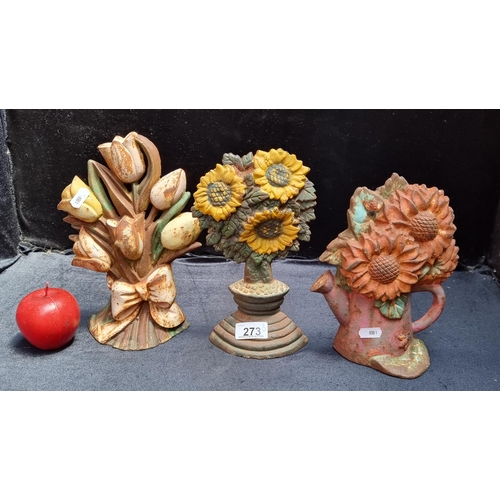 273 - A lot of three brightly coloured antique cast iron door stops with a floral theme including lilies a... 