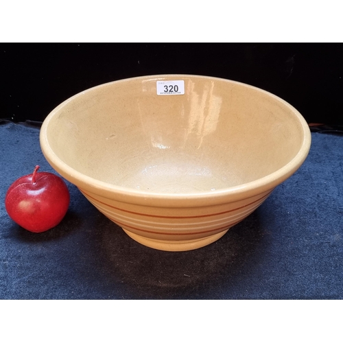 320 - A very heavy good sized stoneware mixing bowl with a charming yellow glaze.