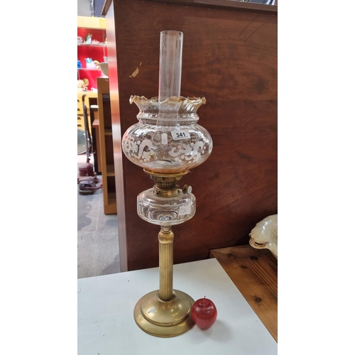 341 - A tall oil lamp with classic column brass stem and fluted smoked glass shade with embossed foliate d... 