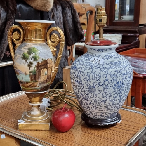 373 - A very ornate urn shaped porcelain vase, with double scroll gilded handles and colourfully illustrat... 