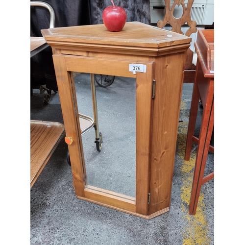 376 - A lovely wooden wall mounting corner storage unit with a mirrored door and retro flower shaped knob.