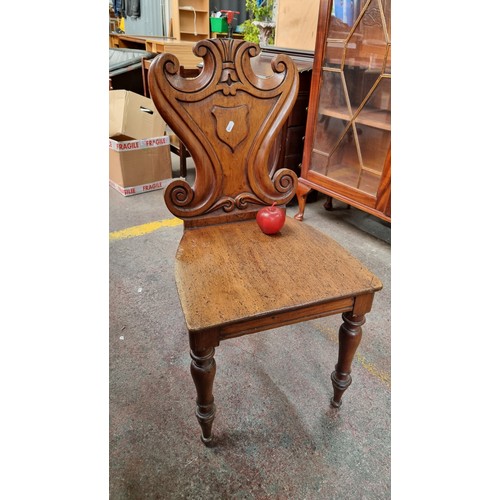 367 - A Victorian mahogany hall chair. With shield back, carved front legs and solid seat.